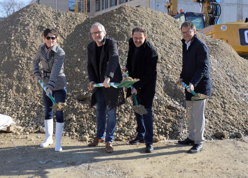 Der Spatenstich betrifft den letzten der drei Gebäude-Würfel der neuen Berufsschule. Der Altbau wurde teilweise im Sommer 2016 abgerissen, seit Herbst 2016 wird die Berufsschule abschnitts-weise neu gebaut.