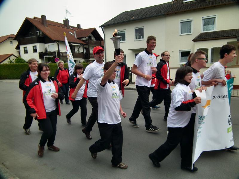 Die Olchinger Sportler bei ihrem Lauf mit der olympischen Flamme durch Olching.